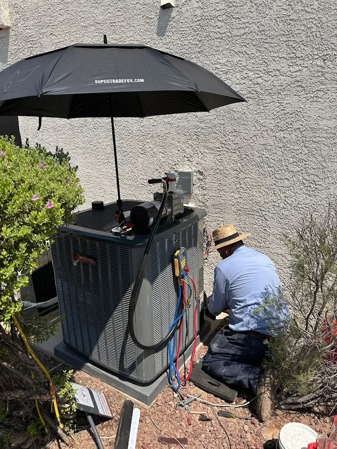 HVAC technician performing outdoor AC maintenance in Chino Valley