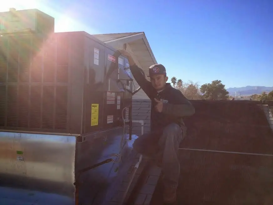 HVAC technician performing AC Tune-Up on a rooftop unit in Chino Valley